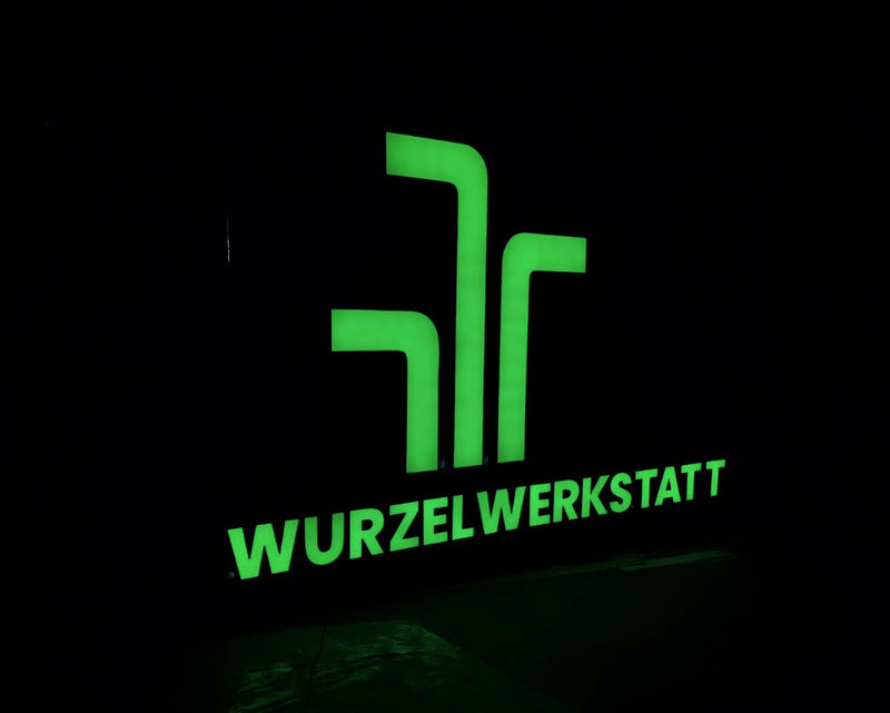 Glowing green logo and text 'Wurzelwerkstatt' in dark