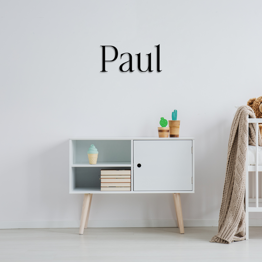 Modern white cabinet with decorative items against a light gray wall with 'Paul' text. Acrylic wall decor - Vibewall