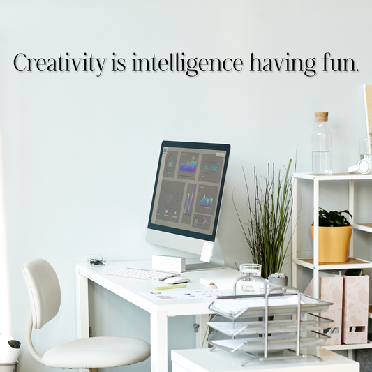 Modern office desk with computer and decor, featuring the quote 'Creativity is intelligence having fun.' - Acrylic wall decor - Vibewall