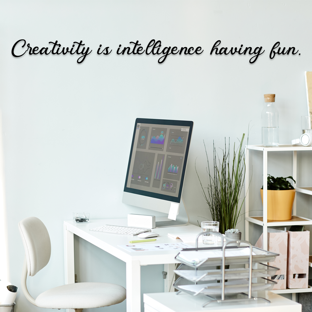 Modern office desk with computer and decor, featuring the quote 'Creativity is intelligence having fun.' - Acrylic wall decor - Vibewall