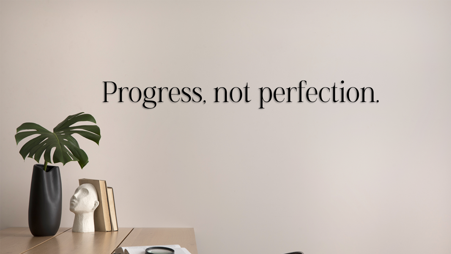 Wall with motivational quote 'Progress, not perfection' above a desk with decor items. Acrylic wall decor - Vibewall
