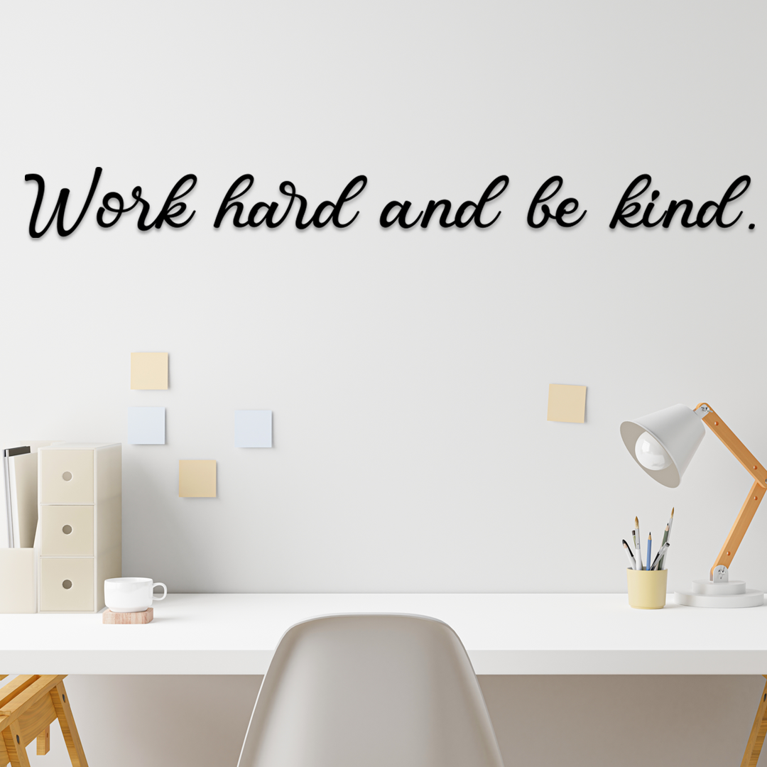 Motivational quote 'Work hard and be kind' on a wall above a desk with office supplies. Acrylic wall decor - Vibewall