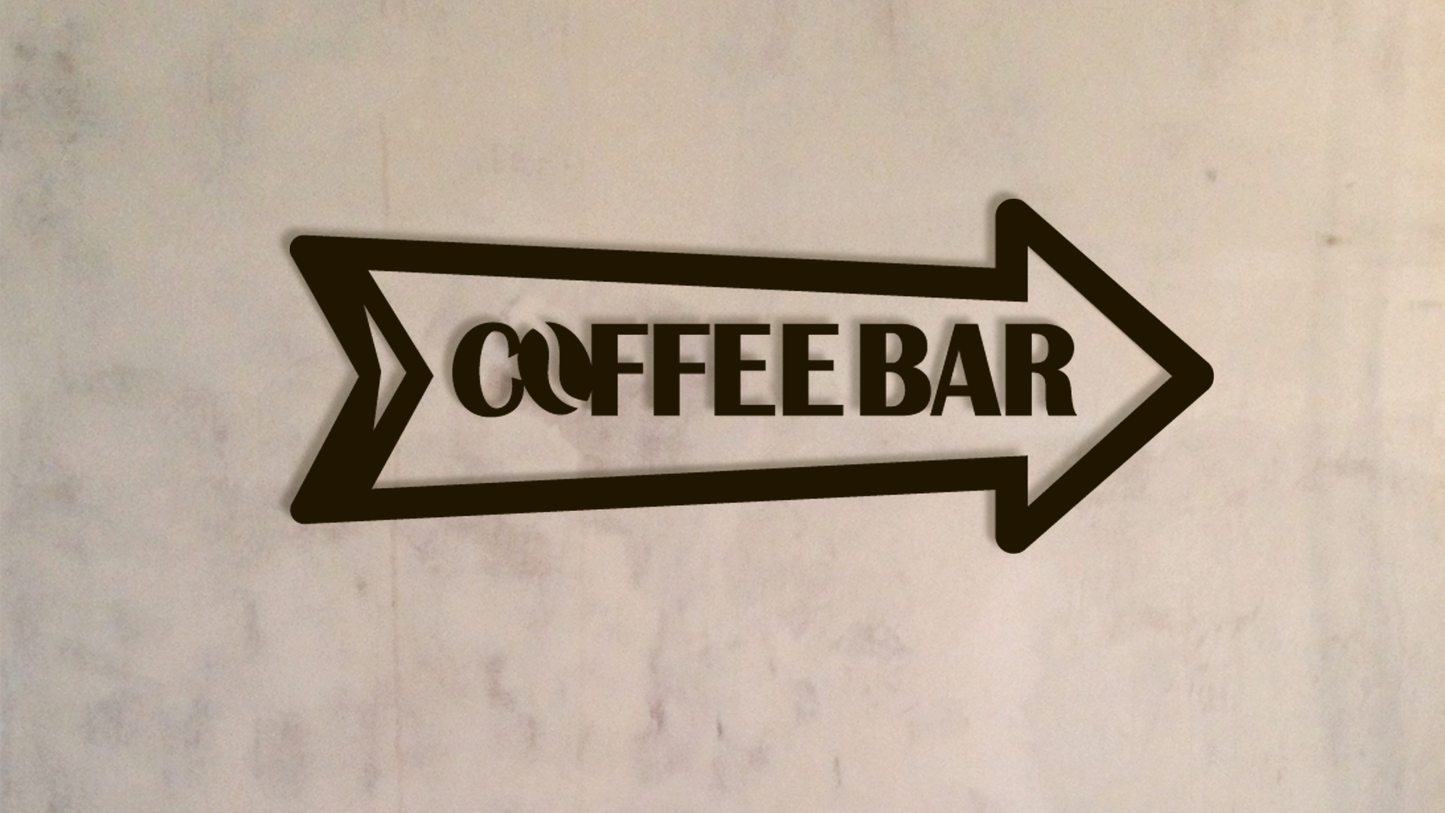 Black arrow-shaped sign with 'COFFEE BAR' text on a textured beige background - Acrylic wall decor - Vibewall 