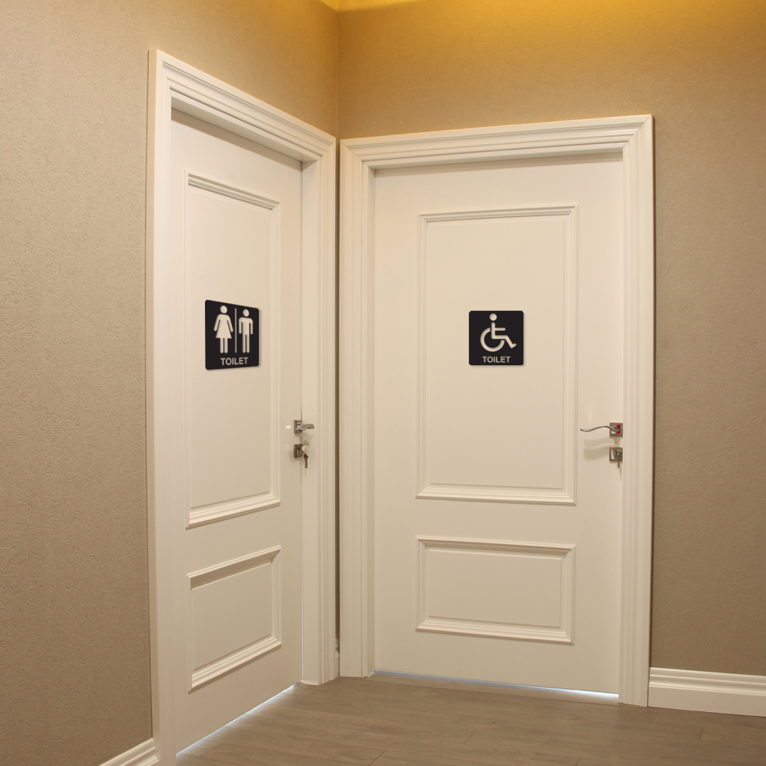 Two white doors with restroom signs on a beige wall. Acrylic wall decor - Vibewall